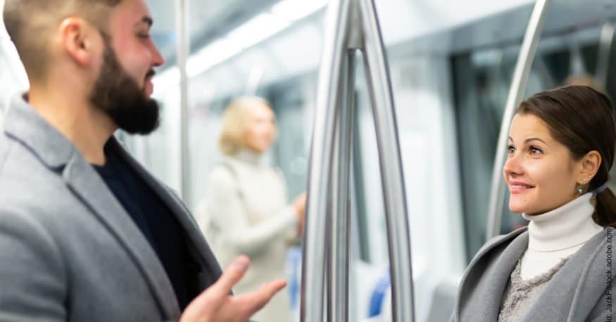 Kürzeste Flirt Anleitung für Männer. Mann flirtet in einem öffentlichen Verkehrsmittel mit einer Frau.
