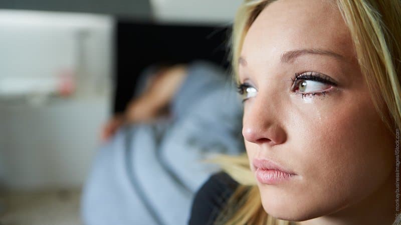 Tränen nach dem Orgasmus. Junge Frau hat Tränen in den Augen, der Mann schläft.