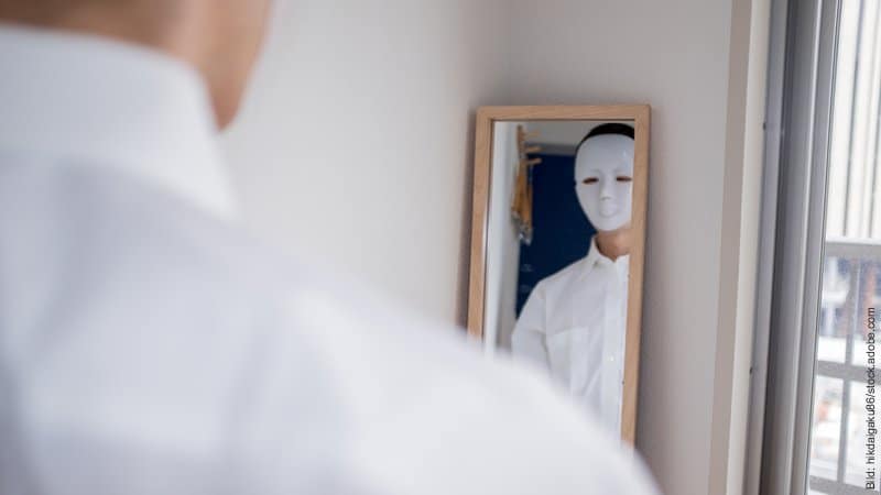 Wenn der Partner lügt - Was tun? Ein Mann mit weißer Maske betrachtet sich im Spiegel.