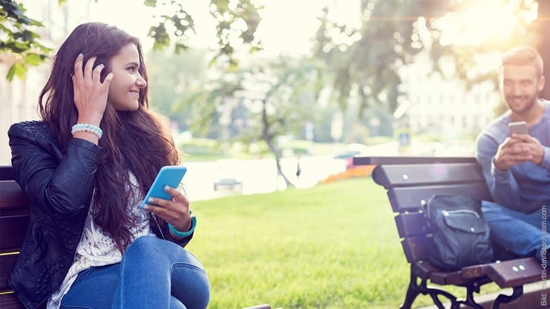 Die 7 Phasen der Trennung. junge Frau flirtet mit jungem Mann im Park.